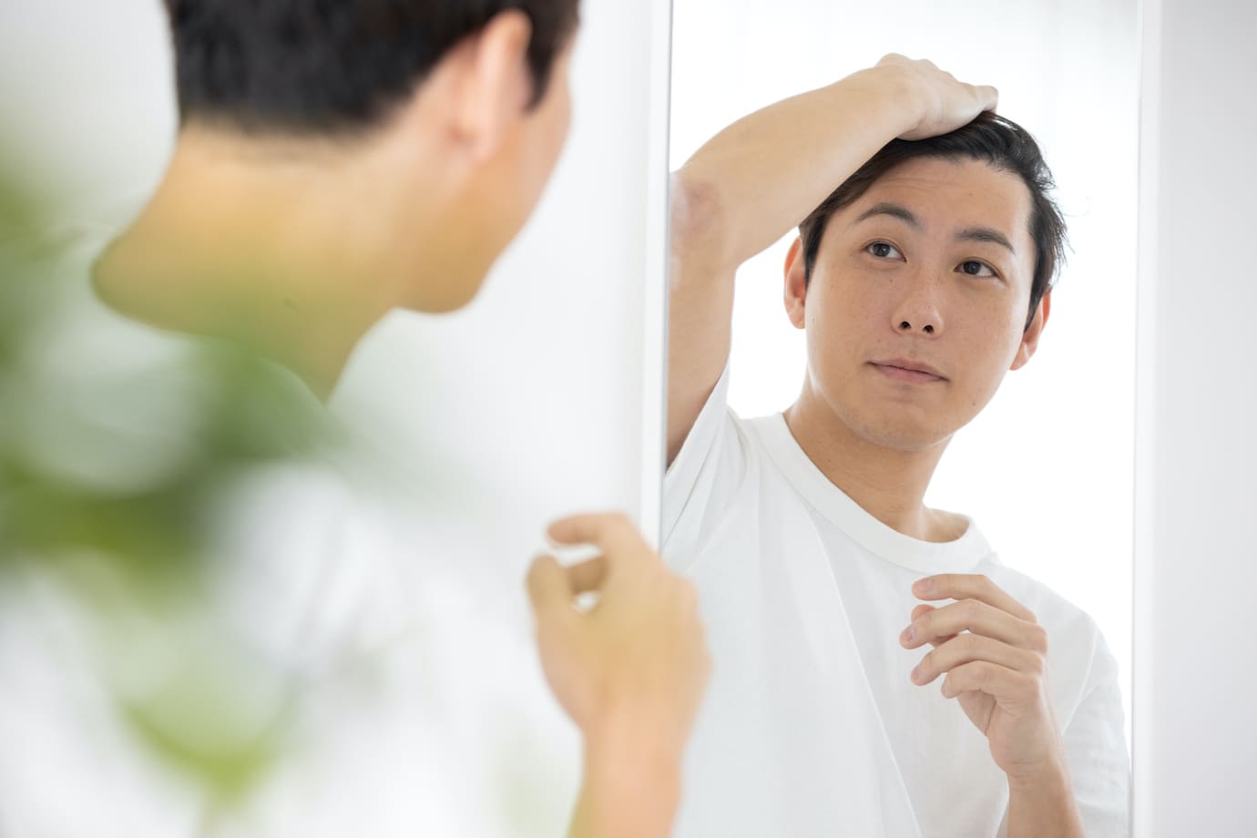 鏡を見る男性